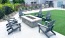 chairs around a fire pit with turf and a building behind it